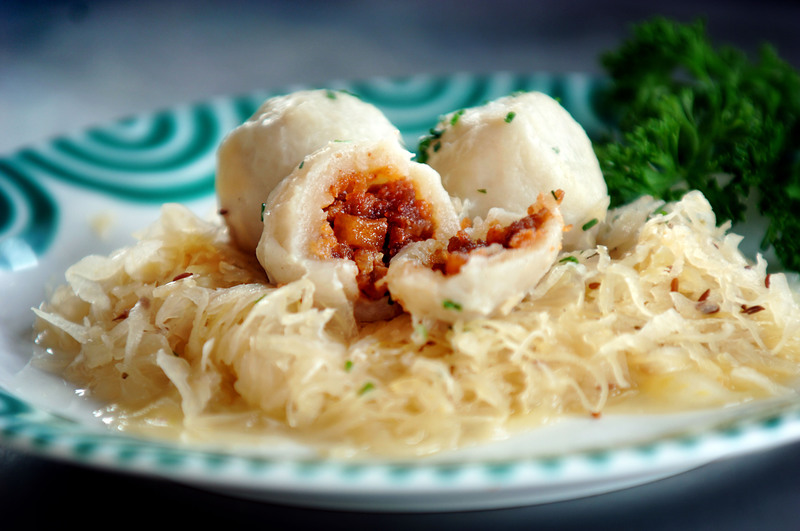  Bratknödel mit Sauerkraut, serviert auf Gmundner Keramiktellern. 